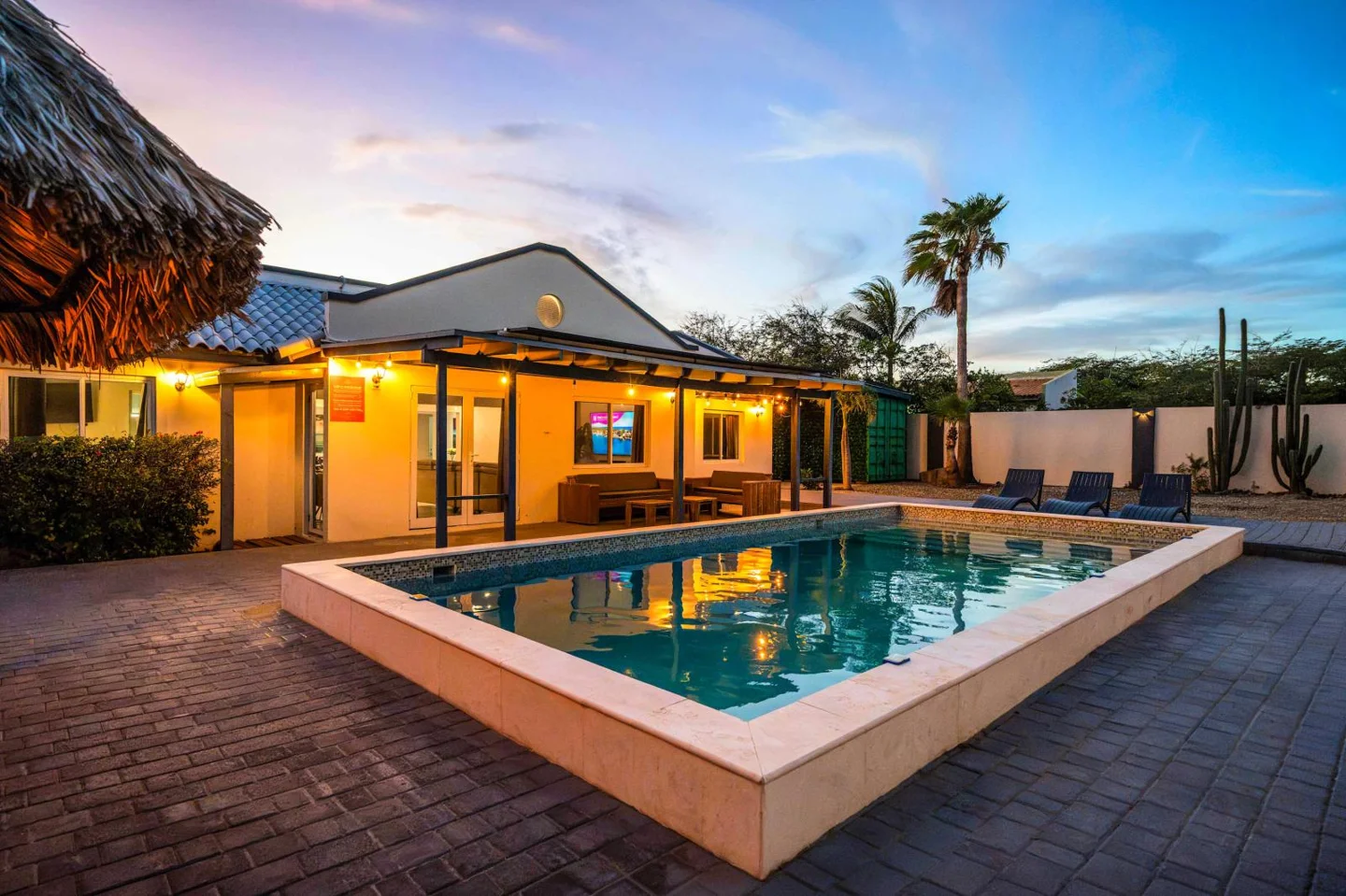 Private swimming pool and villa at sunset