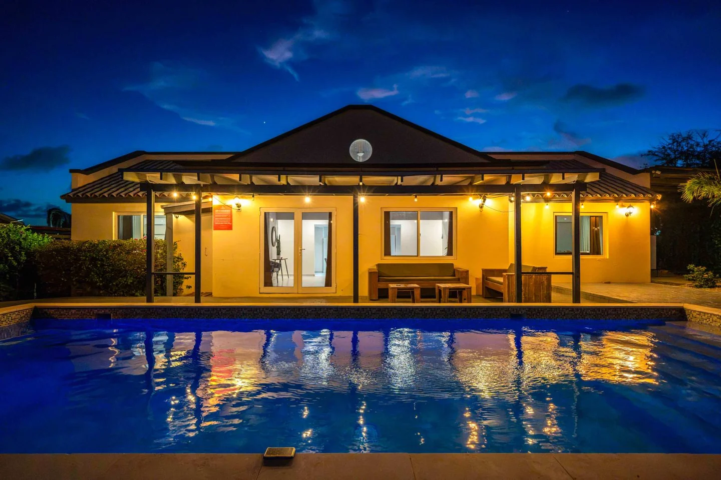 Illuminated pool and villa at night